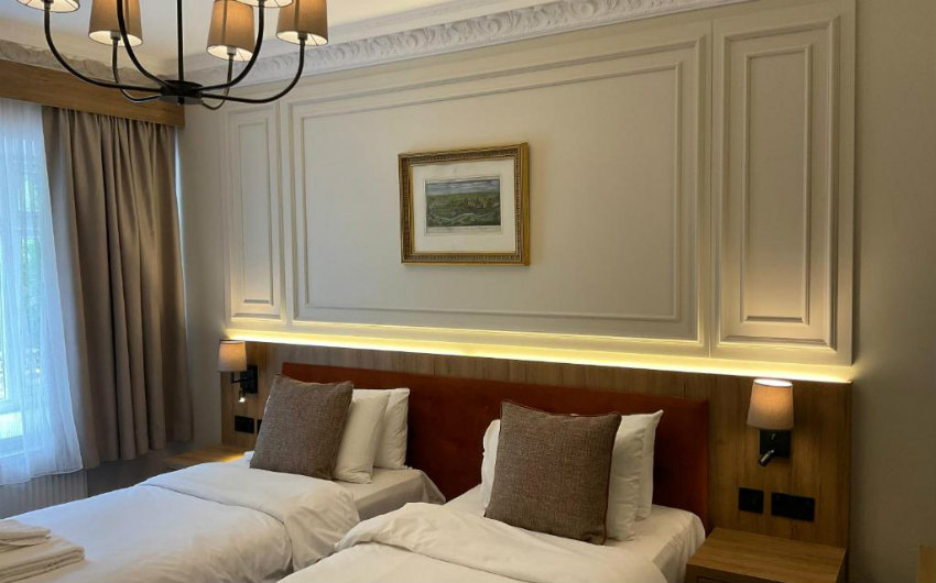 Superior Twin room with chandelier, twin beds and a framed landscape